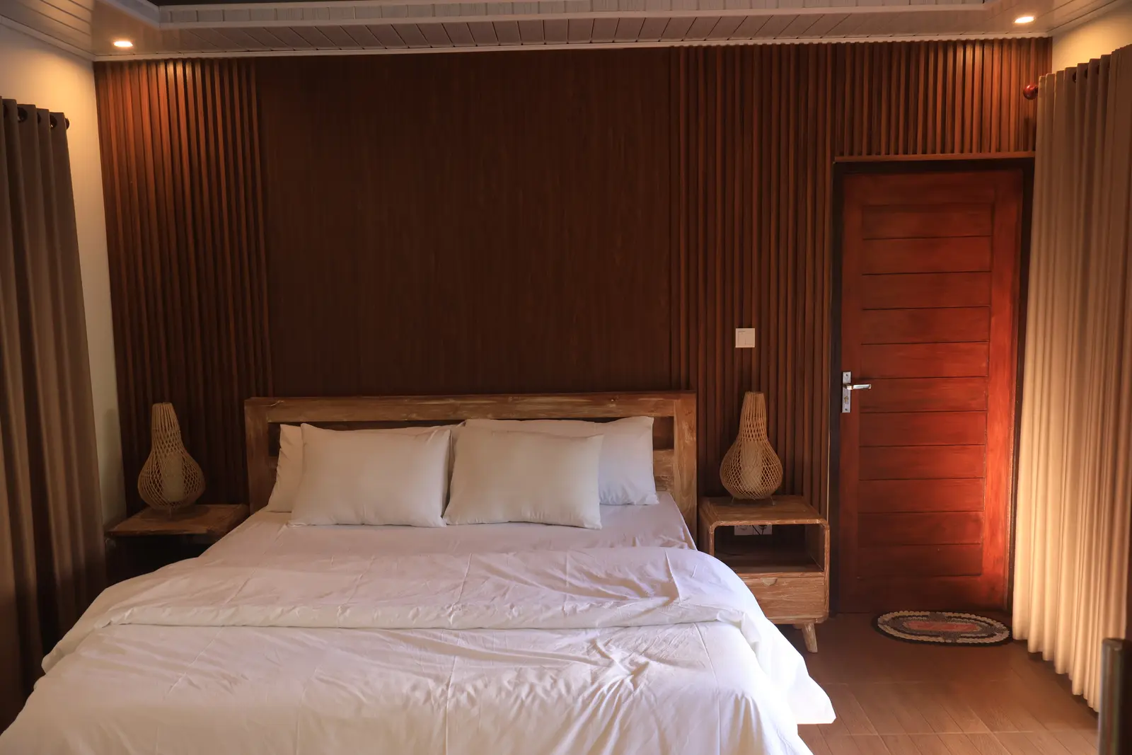 First bedroom with queen bed and warm timber wall